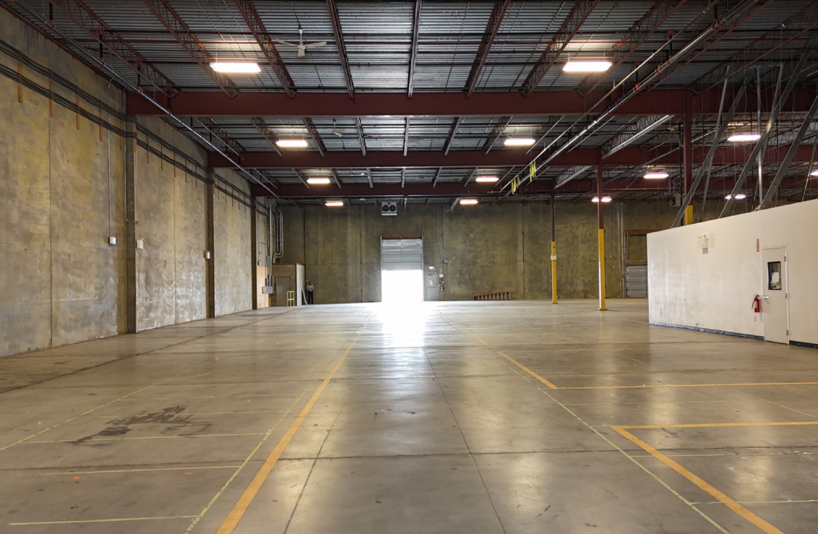 Full-length view of the warehouse floor at 403 East Kent Avenue North toward an open dock door