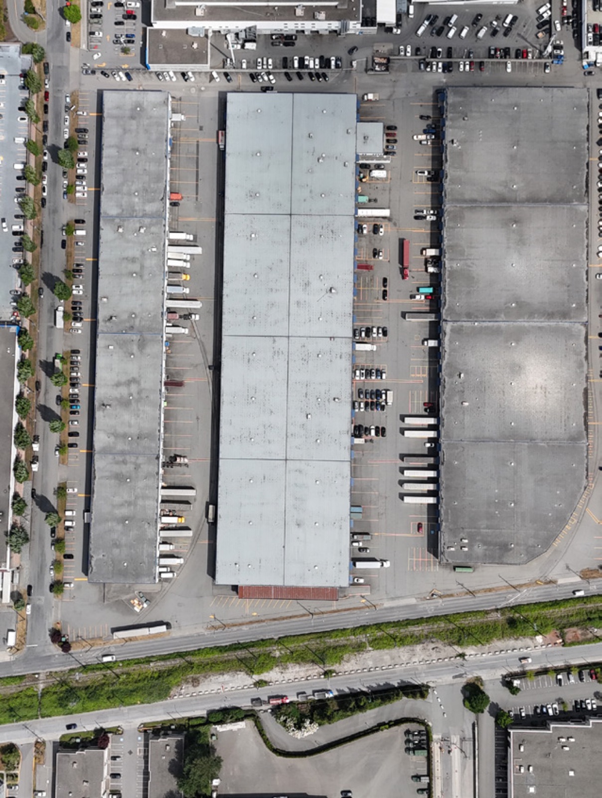 Top-down aerial of Marine Drive Industrial Centre showing the four buildings, truck courts and rail line